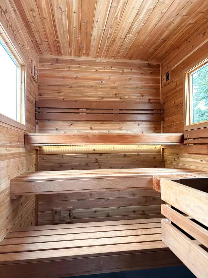 Inside the hot room: three tiers of aspen benches with soft lighting under the top bench